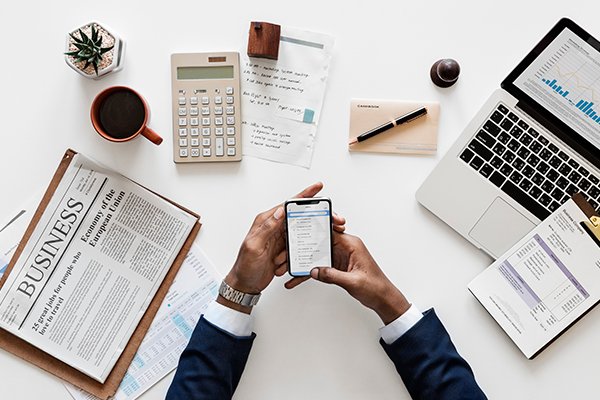 Business books, calculator and a man holding a phone