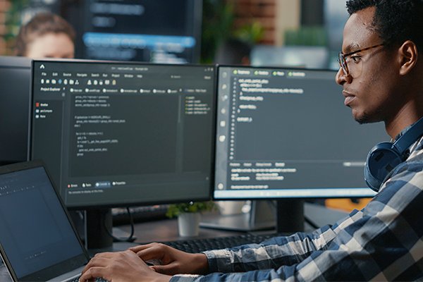 A student sitting in front a desktop and coding