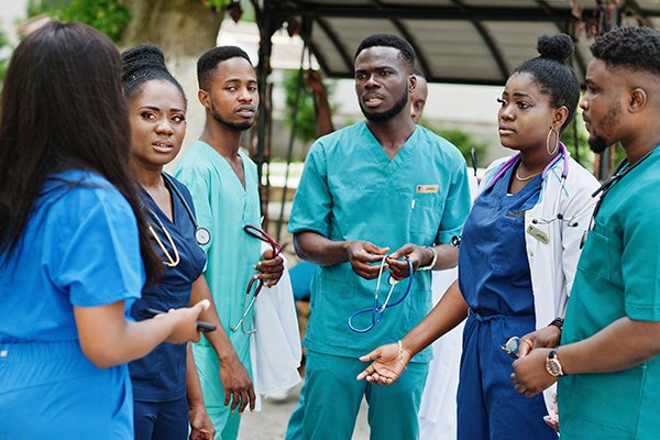 Diploma In Nursing (SRN). Nursing student standing in an open space discussing