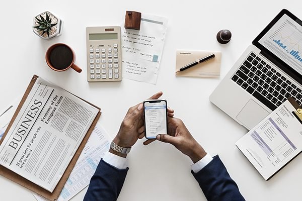 Business books, calculator and a man holding a phone