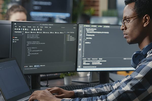 A student sitting in front a desktop and coding