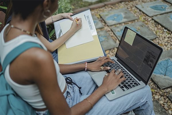 A female student sitting and typing on her laptop